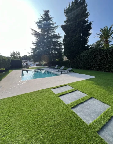 Jardín terminado en Barcelona con césped artificial Pedreña 57 alrededor de la piscina y el camino