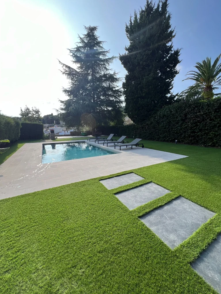 Jardín terminado en Barcelona con césped artificial Pedreña 57 alrededor de la piscina y el camino